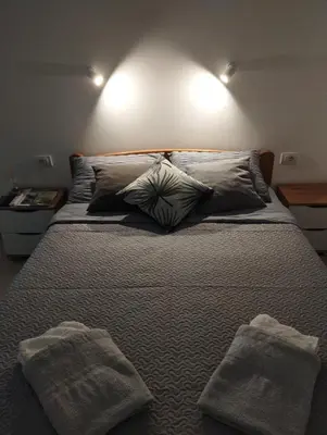 a bed with two pillows and two towels on it at Oaza studio 2 in Soko Banja