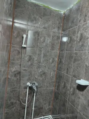 a bathroom with a shower with a tile wall at Смештај Вероника и Симона