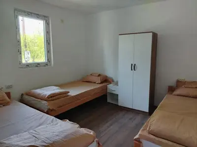 a room with two beds and a cabinet and a window at Смештај Вероника и Симона