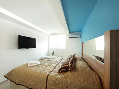 a bedroom with a bed and a flat screen tv at Agent Lux Apartments in Jagodina