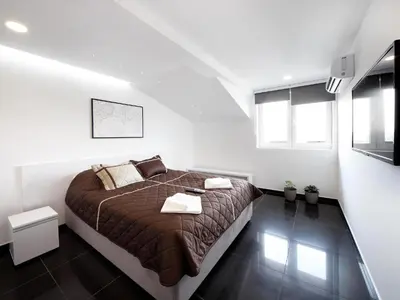 a bedroom with a large bed in a white room at Agent Lux Apartments in Jagodina