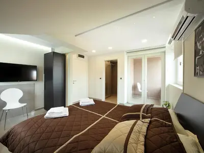 a bedroom with a large bed and a television at Agent Lux Apartments in Jagodina