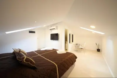 a bedroom with a bed and a desk in a room at Agent Lux Apartments in Jagodina