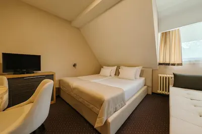 a hotel room with a bed and a television at Central Konaci Apartments & Studio by Husky in Kopaonik