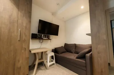 a living room with a couch and a tv on a wall at Central Konaci Apartments & Studio by Husky in Kopaonik