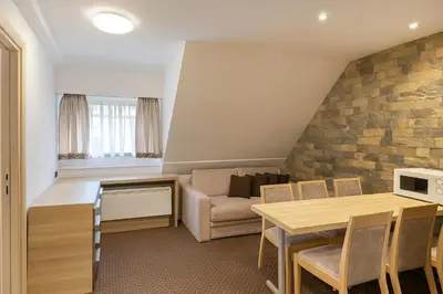 a living room with a table and a couch at Central Konaci Apartments & Studio by Husky in Kopaonik