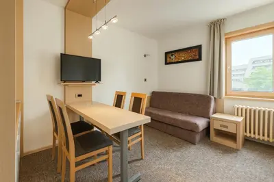 a living room with a table and a couch at Central Konaci Apartments & Studio by Husky in Kopaonik