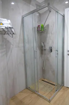 a shower with a glass door in a bathroom at Apartman Sunce Lux N in Vrnjačka Banja