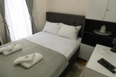 a bedroom with a bed with white towels on it at Apartman Sunce Lux N in Vrnjačka Banja