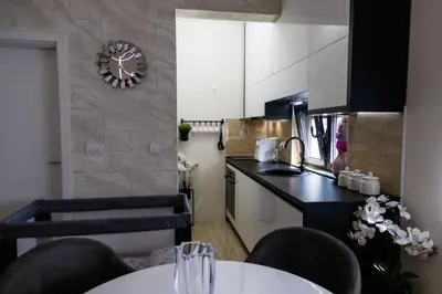 a kitchen with a table and chairs and a counter top at Apartman Sunce Lux N in Vrnjačka Banja
