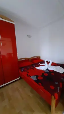 a bedroom with a red bed with white swans on it at Apartman Jezero in Vrnjačka Banja