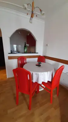 a table and four red chairs in a room at Apartman Jezero in Vrnjačka Banja