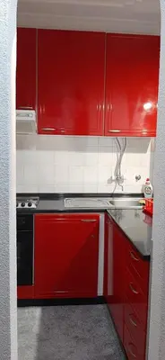 a red kitchen with a stove and red cabinets at Apartman Jezero in Vrnjačka Banja