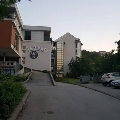 a building with a sign on the side of a street at Apartman Jezero in Vrnjačka Banja
