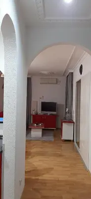 a living room with a television and a wooden floor at Apartman Jezero in Vrnjačka Banja