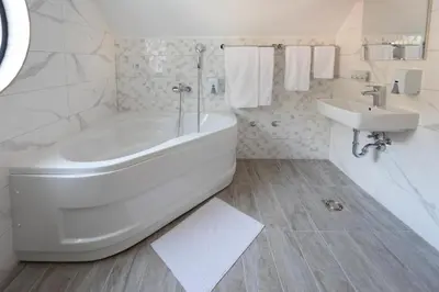 a white bathroom with a tub and a sink at Hotel Bela Jela in Lukovo