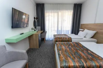 a hotel room with two beds and a television at Hotel Bela Jela in Lukovo