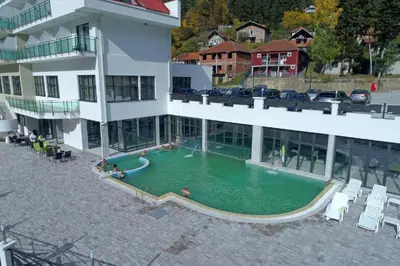 a swimming pool in front of a building at Hotel Bela Jela in Lukovo