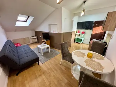 a living room with a table and a couch at Riseup apartman in Niš