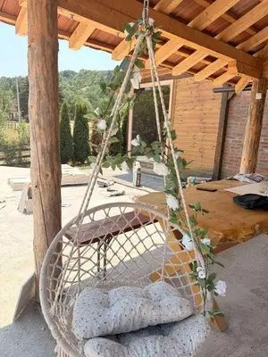 a basket swing with pillows in front of a pavilion at Vikendice Jovicic in Bukorovac