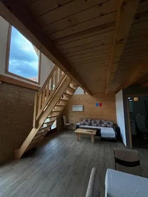 a large room with a bed and a wooden staircase at Vikendice Jovicic in Bukorovac