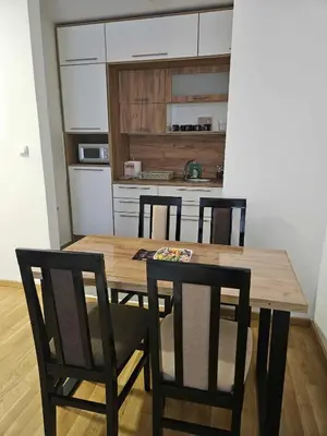 a kitchen with a wooden table and four chairs at Apartman Marija II in Vrnjačka Banja