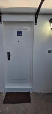 a white garage door with a blue sign on it at Studio Trajkovic in Vranje