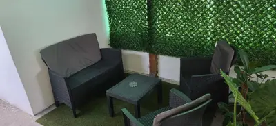 two chairs and a table in front of a green wall at Studio Trajkovic in Vranje