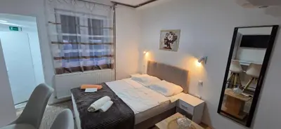a small bedroom with a bed and a mirror at Studio Trajkovic in Vranje