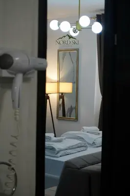 a room with a mirror and a bed with a lamp at Nord Ski - SPA apartman Kraljevi Čardaci in Kopaonik