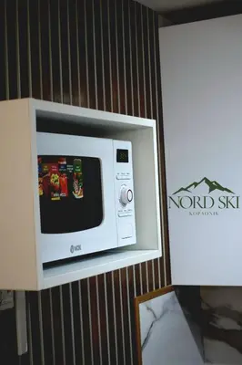 a microwave hanging on a wall in a room at Nord Ski - SPA apartman Kraljevi Čardaci in Kopaonik