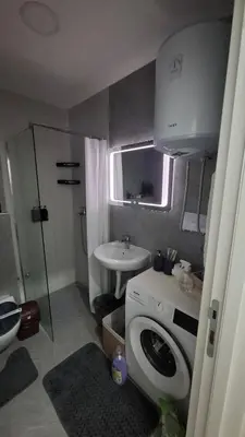 a bathroom with a washing machine and a sink at Apartman Srećko Lux in Vrnjačka Banja