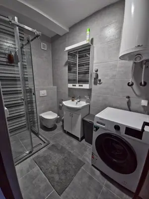 a bathroom with a shower and a washing machine at ALDA Apartmani Vranje in Vranje