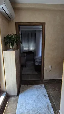 a room with a door open to a bedroom with a plant at ALDA Apartmani Vranje in Vranje