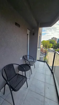 two chairs and a table on a balcony at ALDA Apartmani Vranje in Vranje