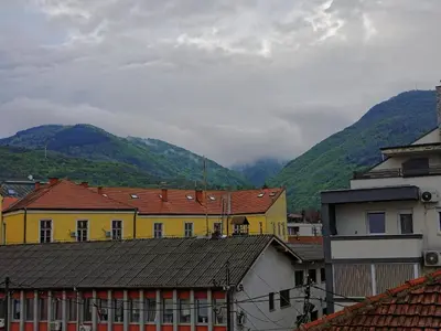 a group of buildings with mountains in the background at ALDA Apartmani Vranje in Vranje