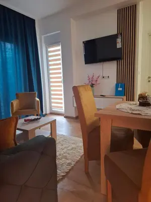 a living room with a table and a tv at Apartman Jelena AS in Vrnjačka Banja