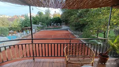a tennis court with a chair on a balcony at Apartman Orhideja in Vrnjačka Banja