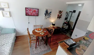 a living room with a table and a dining room at Apartman Orhideja in Vrnjačka Banja