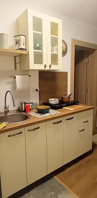 a kitchen with white cabinets and a sink at Apartman Orhideja in Vrnjačka Banja