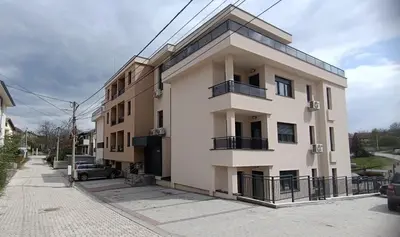 a large white building on the side of a street at Apartman Orhideja in Vrnjačka Banja