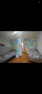 a room with two beds and a door in it at V U Sobe in Brzi Brod