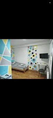 a room with a bed and a desk and a tv at V U Sobe in Brzi Brod