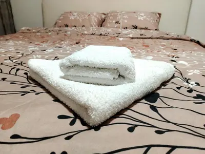 a pile of towels sitting on top of a bed at Apartman Zdravković in Leskovac