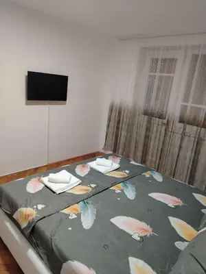 a bed with a blanket with butterflies on it at Apartman Zdravković in Leskovac
