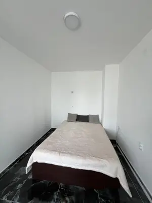 a bedroom with a bed in a white room at Apartman Boža 1 in Kuršumlija