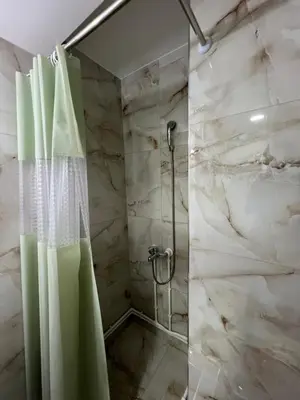a bathroom with a shower with a shower curtain at Apartman Boža 1 in Kuršumlija