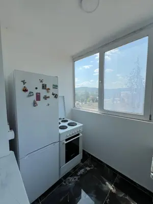 a white kitchen with a stove and a window at Apartman Boža 1 in Kuršumlija