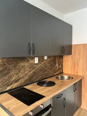 a kitchen with gray cabinets and a stove top oven at Apartman Boža 2 in Kuršumlija