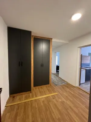 an empty room with black cabinets and wood floors at Apartman Boža 2 in Kuršumlija
